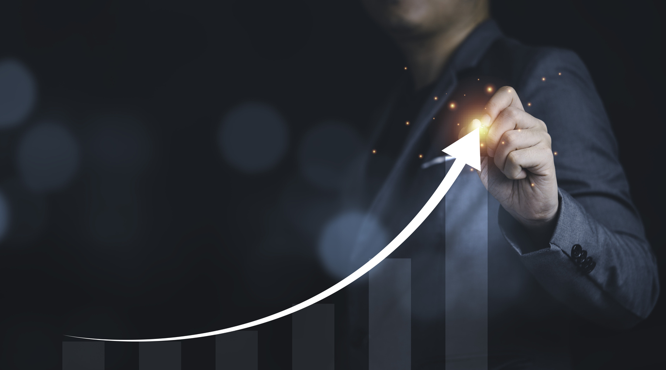 Businessman writing growth increasing arrow with chart and graph