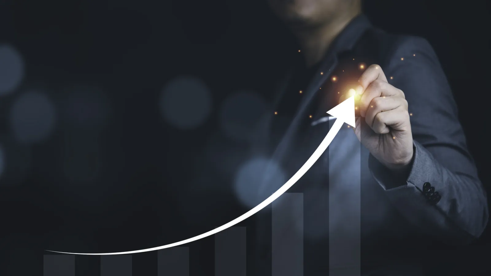 Businessman writing growth increasing arrow with chart and graph
